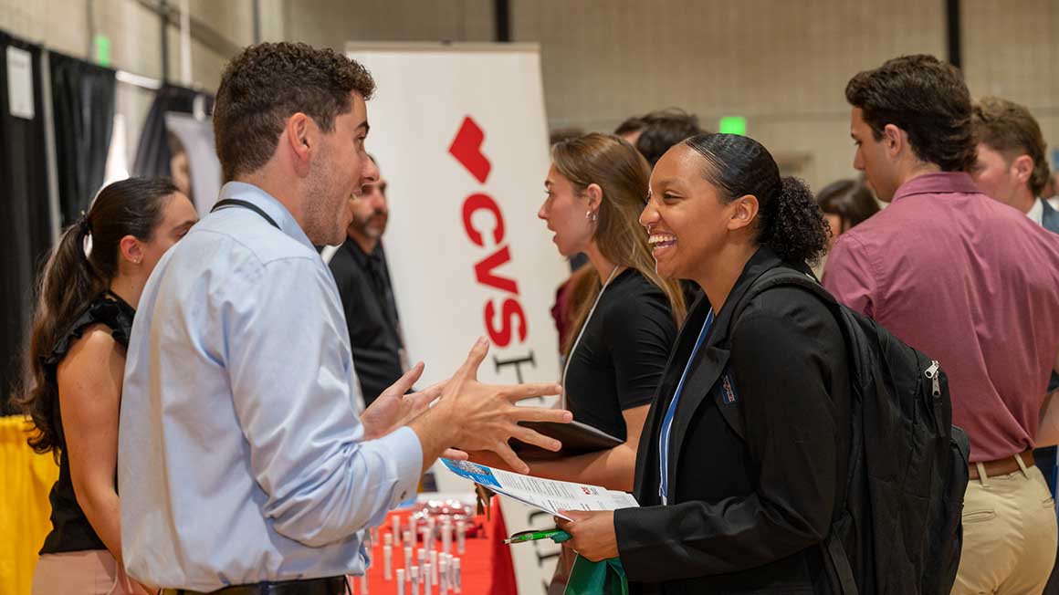 A Bryant University student speaks with a representative from CVS Health at the Fall Career Fair.
